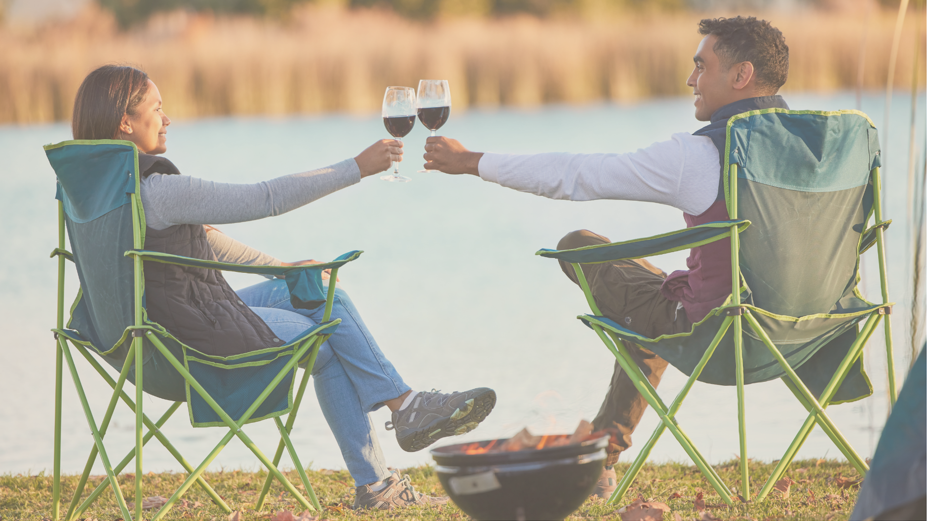 A young couple relaxing by a lake during a luxury RV trip, enjoying scenic views and high-end off-grid amenities.